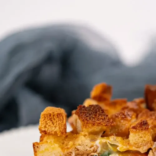 A simple sausage and egg casserole baked to a golden brown perfection in a white baking dish.