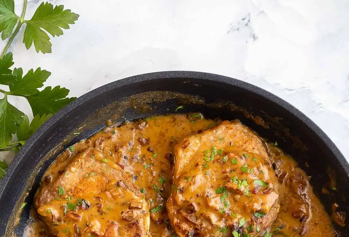 A plate of rich smothered pork chops with gravy