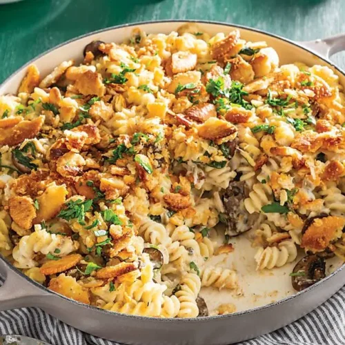 A steaming hot tuna noodle casserole in a baking dish, fresh from the oven.